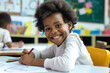 © Irina B - Smiling child with curly hair drawing with colored pencils in a classroom setting, yellow chair in the background.