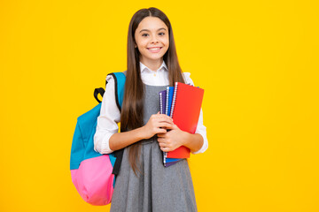 Wall Mural - Back to school. Schoolgirl student hold book on yellow isolated studio background. School and education concept. Teenager girl in school uniform.