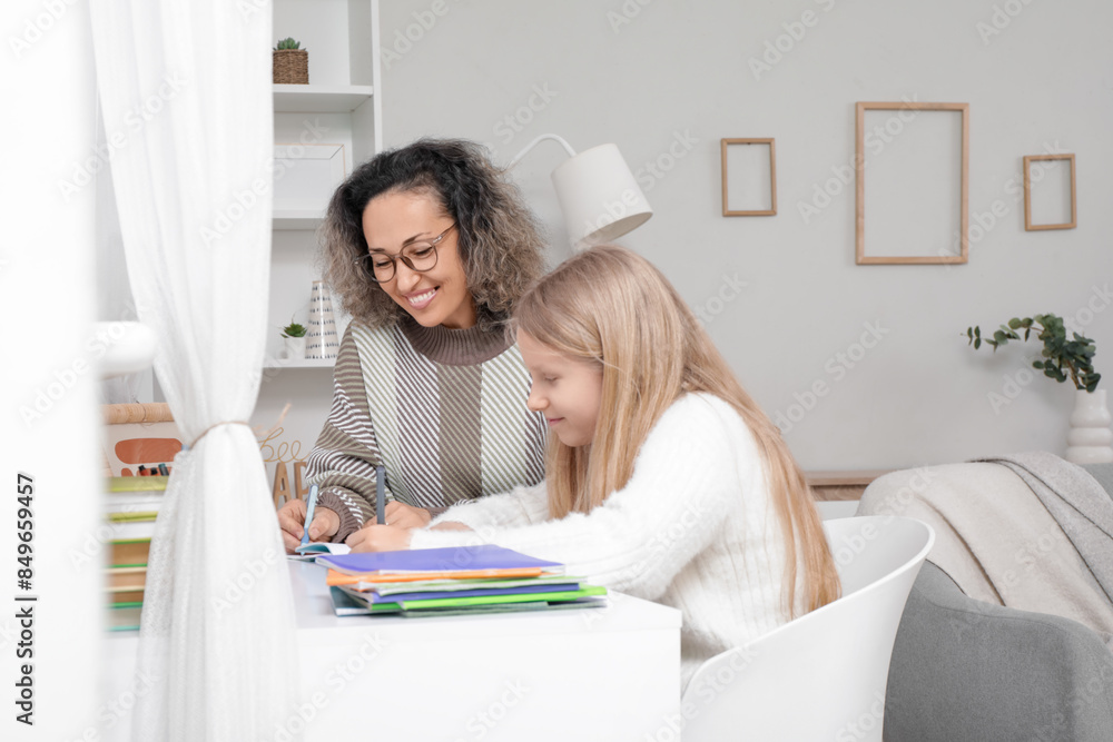 Little girl studying with tutor at home