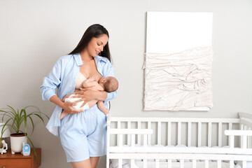 Wall Mural - Beautiful young happy woman breastfeeding her baby in bedroom at home