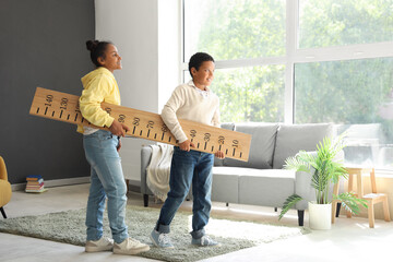 Poster - Little African-American children carrying stadiometer at home