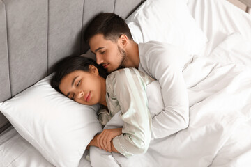 Canvas Print - Young woman with her husband lying in bedroom