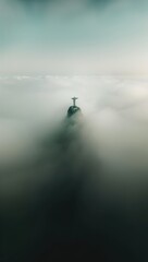 Wall Mural - Aerial view of Christ statue on top of a mountain in the fog.