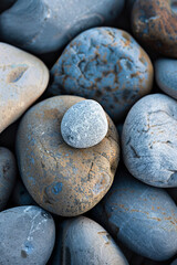 Wall Mural - A single, perfectly round pebble among jagged rocks 