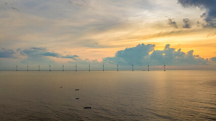 Wall Mural - windmill park with clouds and a blue sky, wind mill turbines in the ocean aerial view of a wind farm