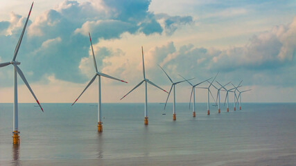 Wall Mural - windmill park with clouds and a blue sky, wind mill turbines in the ocean aerial view of a wind farm