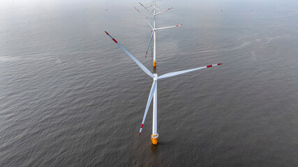 Wall Mural - windmill park with clouds and a blue sky, wind mill turbines in the ocean aerial view of a wind farm