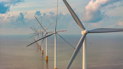 Wall Mural - windmill park with clouds and a blue sky, wind mill turbines in the ocean aerial view of a wind farm