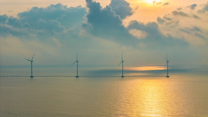 Wall Mural - windmill park with clouds and a blue sky, wind mill turbines in the ocean aerial view of a wind farm