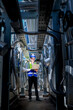 © ultramansk - An industrial worker in high-visibility gear and a blue helmet meticulously examines the intricate network of machinery. The engineer is dedicated to maintaining operational efficiency and safety.