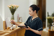 © DragonImages - Spa salon manager checking price list and procedure description