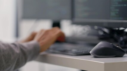 Wall Mural - a close-up shot of a professional programmer’s hands typing code on a keyboard, with multiple monito