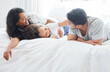 © Talia Mdlungu/peopleimages.com - Child, parents and family in bed for morning with love relationship, parent support and bonding together in home. Mother, father and young girl in bedroom for wake up with lazy weekend and relax