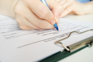 Affidavit of small estate, hand fills out a document, mortgage agreement, property investment, finance management.