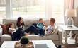 © Reese Coop/peopleimages.com - Relax, children and happy family in home with parents together for care, love or bonding. Kids, mother and father on sofa for support, conversation or play with funny siblings laughing in living room