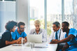 © peopleimages.com - Meeting, laptop and medical team in office for healthcare, discussion and expertise in hospital. Men, women and specialist at table for collaboration, consulting and problem solving in boardroom