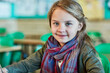 © NonVig/peopleimages.com - School, classroom and portrait of kid with pen for learning, development and assessment in morning. Little girl, face and happy by desk with smile for education, lesson and growth in knowledge