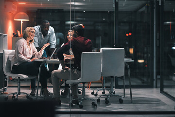 Fototapete - Business meeting, laptop and support for design at night in office, creative agency and overtime for project talk. Teamwork, people and problem solving and planning for deadline or discussion