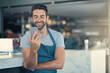 © peopleimages.com - Barista, man and smartphone in cafe with apron for communication, networking or restaurant app. Connection, small business owner and male person for social media, browsing internet or online order