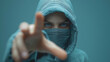 © CreativeIMGIdeas - A person wearing a hoodie and a face mask is pointing at something