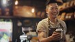 © Generative AI - Smiling male owner wearing apron holding coffee cup at cafe : Generative AI