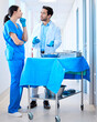 © peopleimages.com - Conversation, dentist and nurse in hospital for teamwork, surgery and collaboration for results. Man, assistant and medical workers in clinic for planning, tools and professional people in workplace