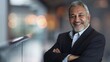 © Generative AI - Handsome hispanic senior business man with crossed arms smiling at camera Indian or latin confident mature good looking middle age leader male businessman on blur office background wit : Generative AI