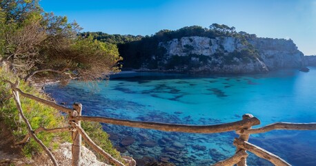 Sticker - landscape view of the idyllic Cala Macarella in southern Menorca with a hiking trail in the foreground