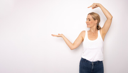 Wall Mural - Young woman pointing fingers to the side over isolated white background