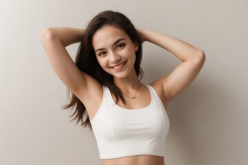 Wall Mural - Young woman with bright skin wearing a white tank top showing her armpit on a beige background with copy space.