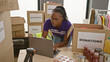 © Krakenimages.com - African american woman volunteers at donation center using laptop indoors