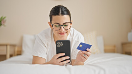 Wall Mural - Young beautiful hispanic woman shopping online lying on bed at bedroom