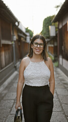 Canvas Print - Confident hispanic woman, beautiful and joyful, cheerfully posing with glasses on, standing and smiling on kyoto's traditional streets, radiating natural and carefree latin expression.