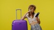© kinomaster - Young woman in casual with suitcase talking on smartphone. Travel, summertime vacation, tourism leisure time concept.
