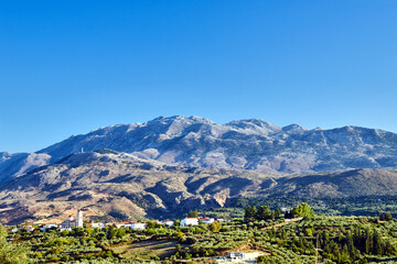 Wall Mural - A town in the valley and rocky peaks in the Lefka Ori mountains on the island of Crete