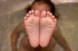 © Sabrina - Toddler showing her wrinkled wet feet in a bathtub. Scene from above
