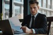 © Kate - young male businessman working with documents while sitting in the office at his desk