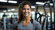 © SKOPUS DRON - A latin woman on her 30's, in grey T-shirt smiling in a gym. Training services, fitness coaching, gym employee staff, body wellness, physical well-being, active lifestyle.