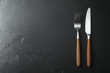 Wall Mural - Stylish cutlery on black table, top view. Space for text
