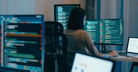 Young Asia female freelance eyeglasses typing write prompt AI bot IT app smart program nomad, video game, terminal with coding language, designer, big data center on desktop computer in night office.