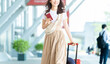 © Trickster* - 空港でパスポートを持つ旅行中の女性