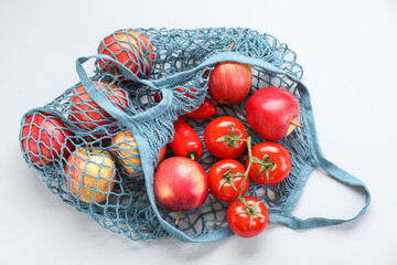 Sticker - String bag with vegetables and apples on light grey background, top view