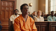 © Babb - A man in an orange shirt sits in a courtroom with other people