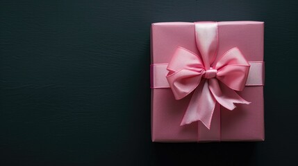 Wall Mural - Top view of pink gift box with bow on black background