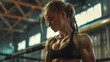 © Prostock-studio - A woman with braids poses in a gym. She is wearing a black sports bra and has a serious expression on her face.