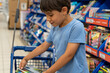 © ADDICTIVE STOCK - Young boy shopping for school supplies in a store