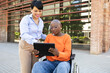 © ADDICTIVE STOCK - Latin American businesswoman assisting woman in wheelchair