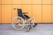 © ADDICTIVE STOCK - Modern wheelchair against orange wall