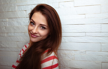 Wall Mural - Happy positive woman with long brown healthy hair on studio white wall background with empty copy space. Closeup portrait