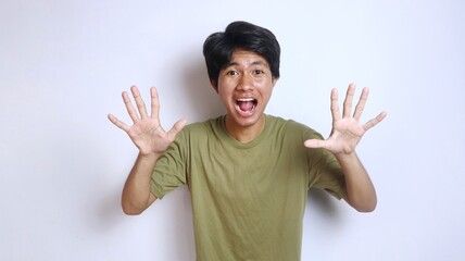 Wall Mural - Excited young Asian man with wide open hand gesture